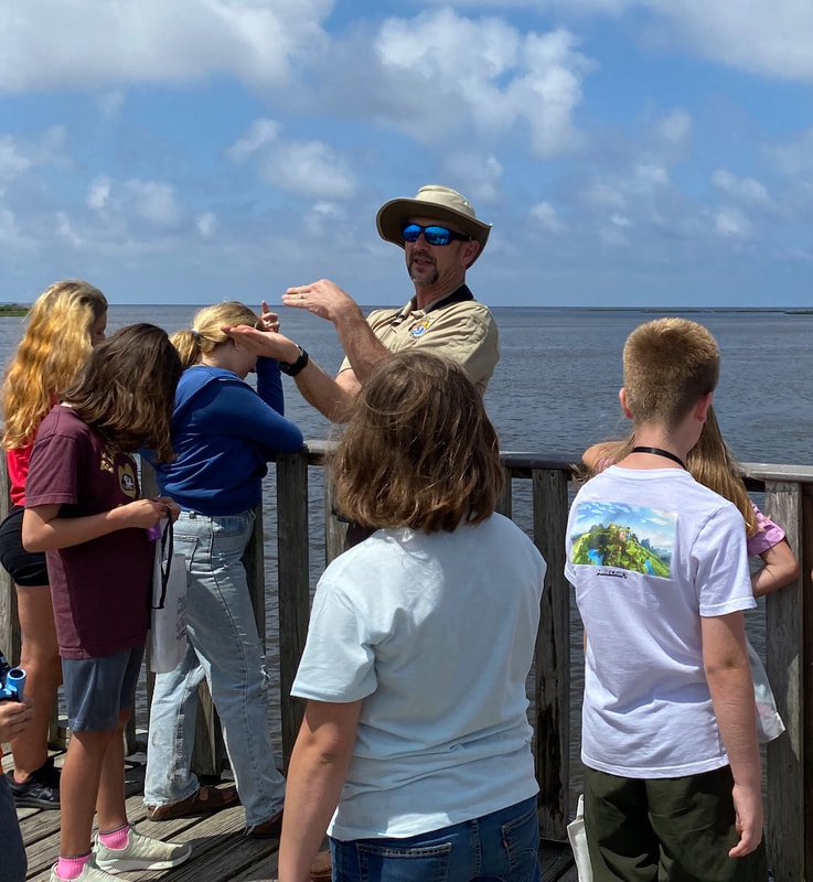 Deputy Manager Stark talking to children on the Shell Mound pier