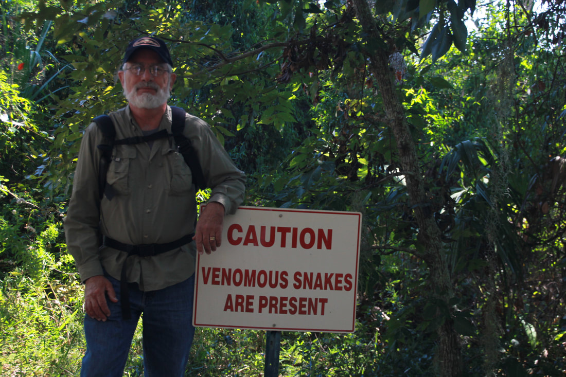 Picture of Visitor standing near warning sign about venomous snakes