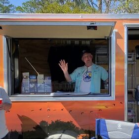 Picture of man waving from the window of the Mobile Outreach Trailer