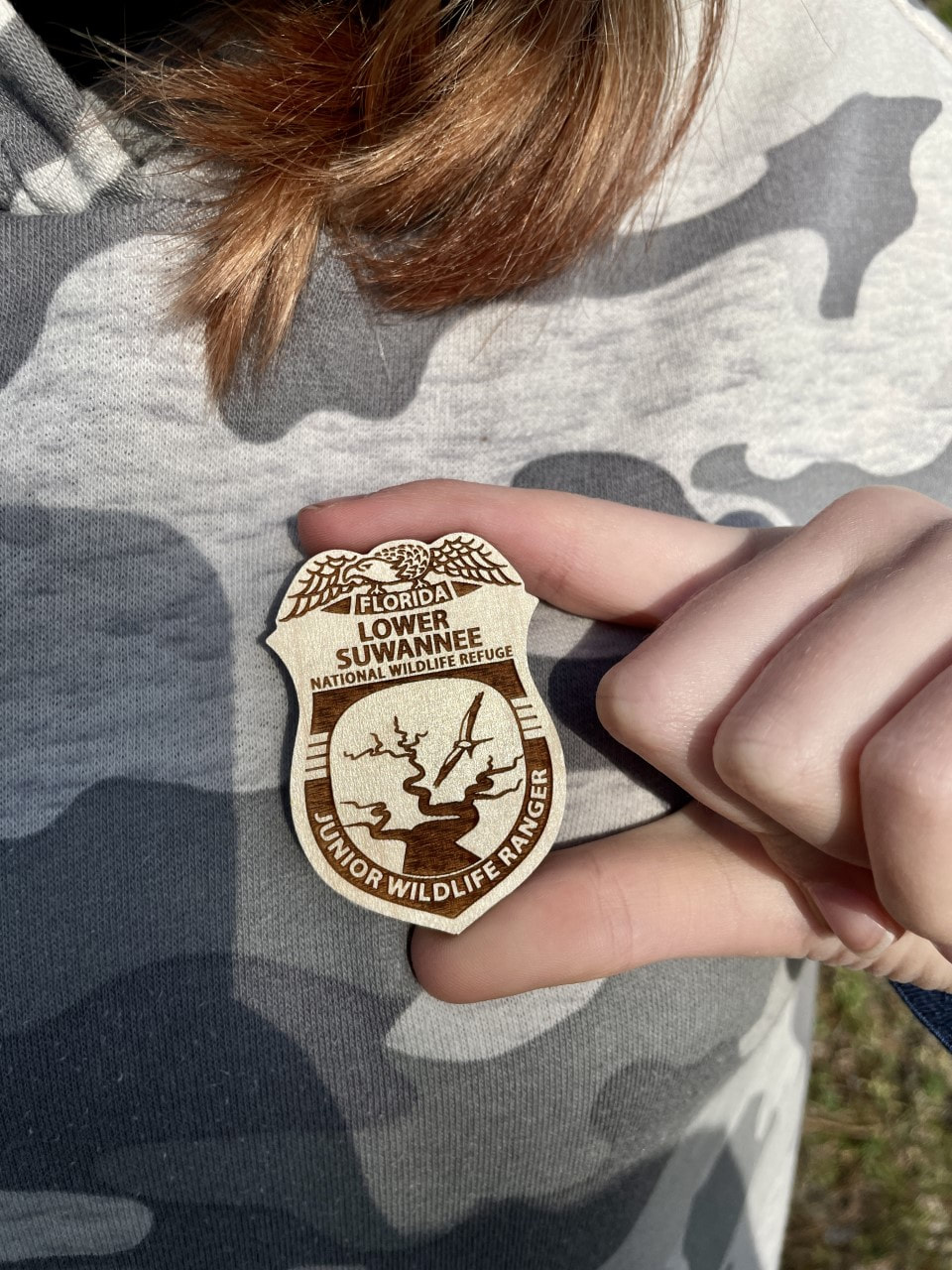 Picture of a Junior Ranger badge being given to a girl.