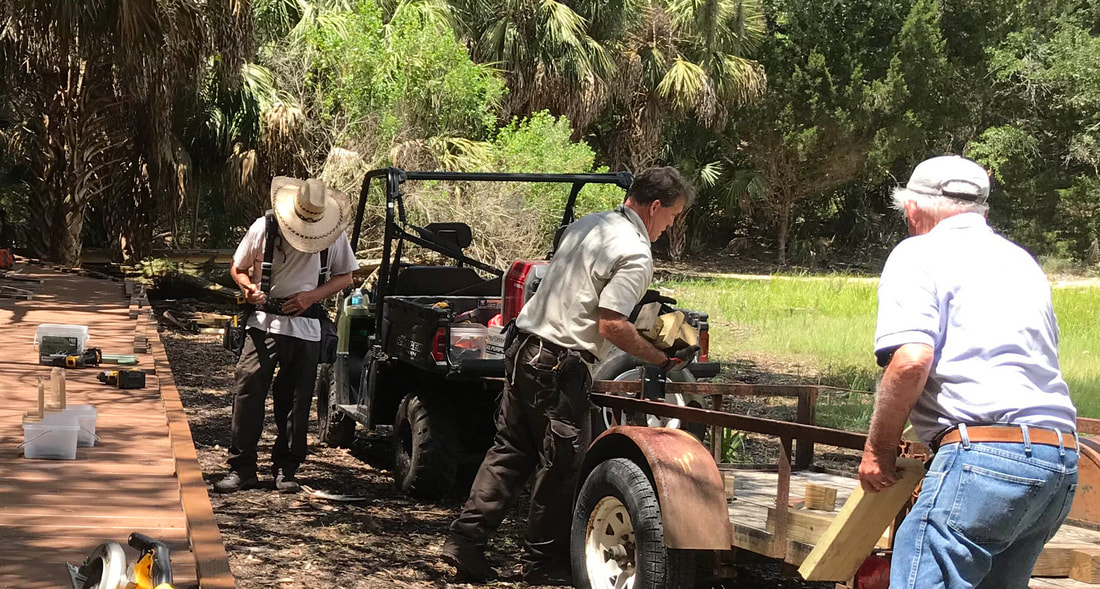 Picture of Ron, on the right, working with the rest of the refuge staff to build a board walk at Shell Mound