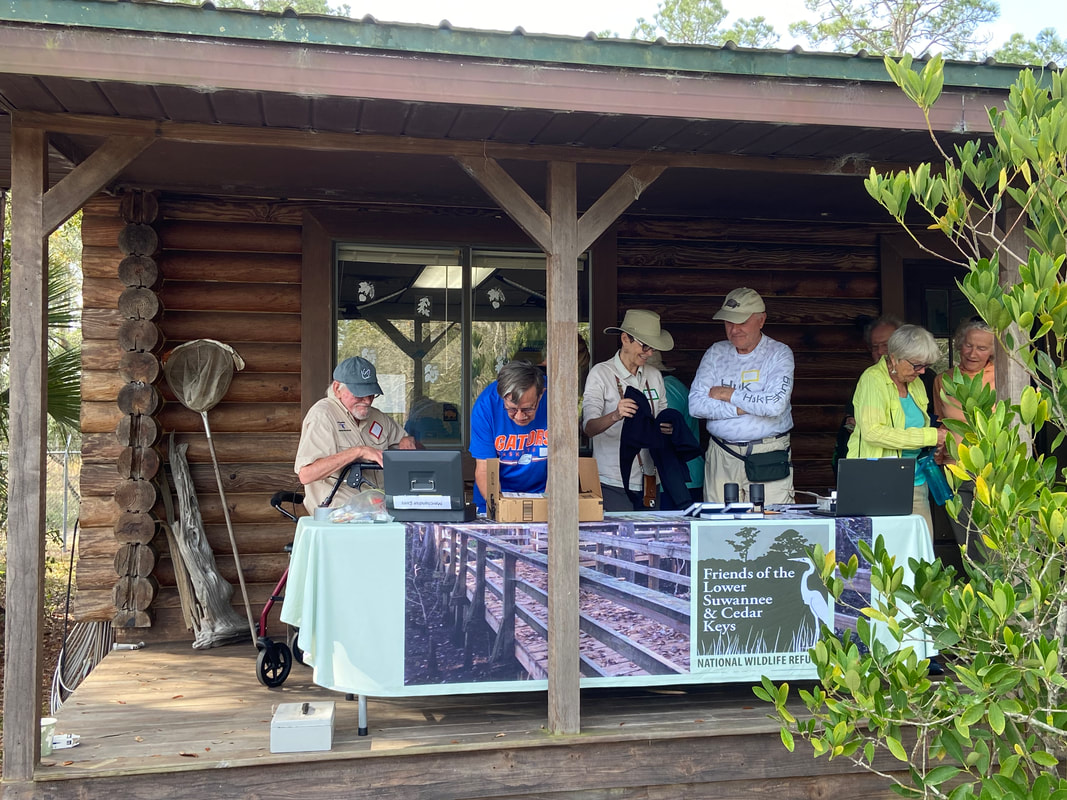 Picture of Friends members at the merchandise booth at the log cabin  at the Annual Meeting 2023