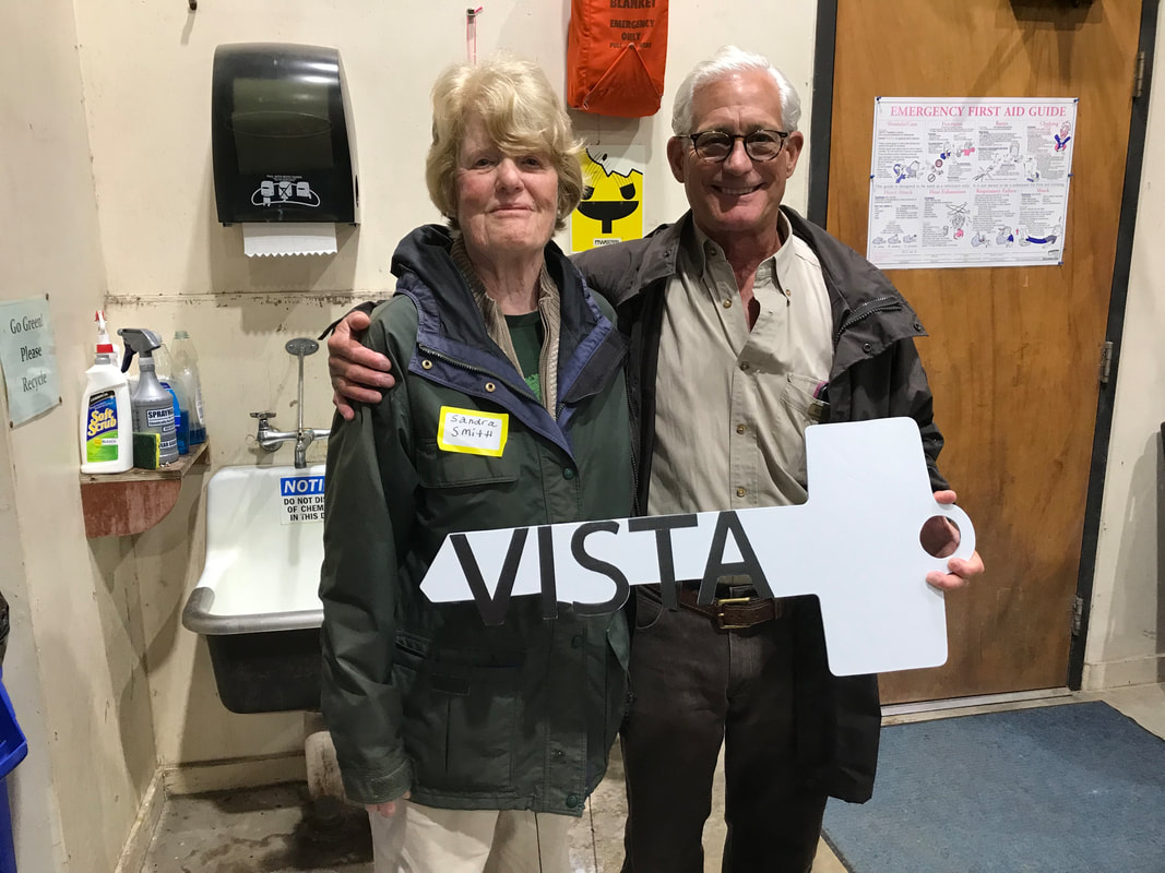Picture of Sandra Roe Smith and Andrew Gude as she symbolically turns over the key to Vista