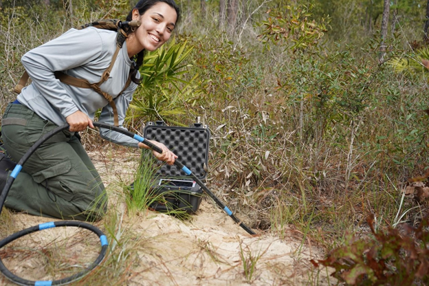 Picture of Jasmine Muslimani working near a gopher tortoise burrow