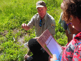 Picture of Refuge Forester Daniel Barrand working with the students on a citizen science project