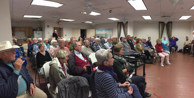 Picture of a crowd watching a talk at the Cedar Key Library